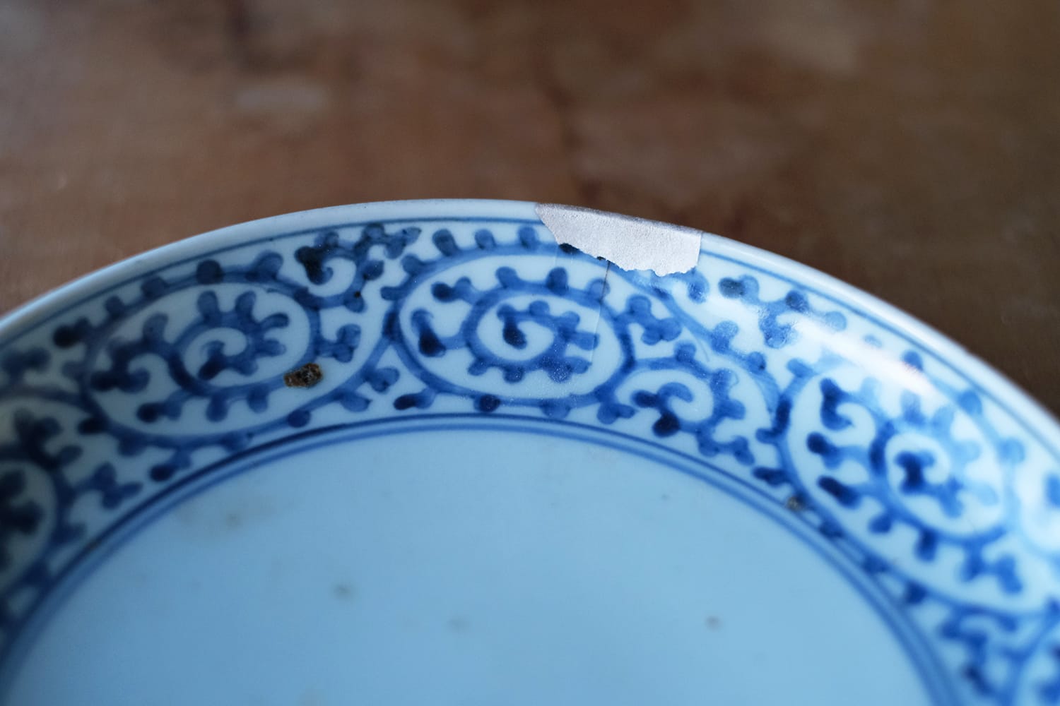 欠けた部分を刻芋漆と銀継ぎで補修した蛸唐草文様の古伊万里の皿