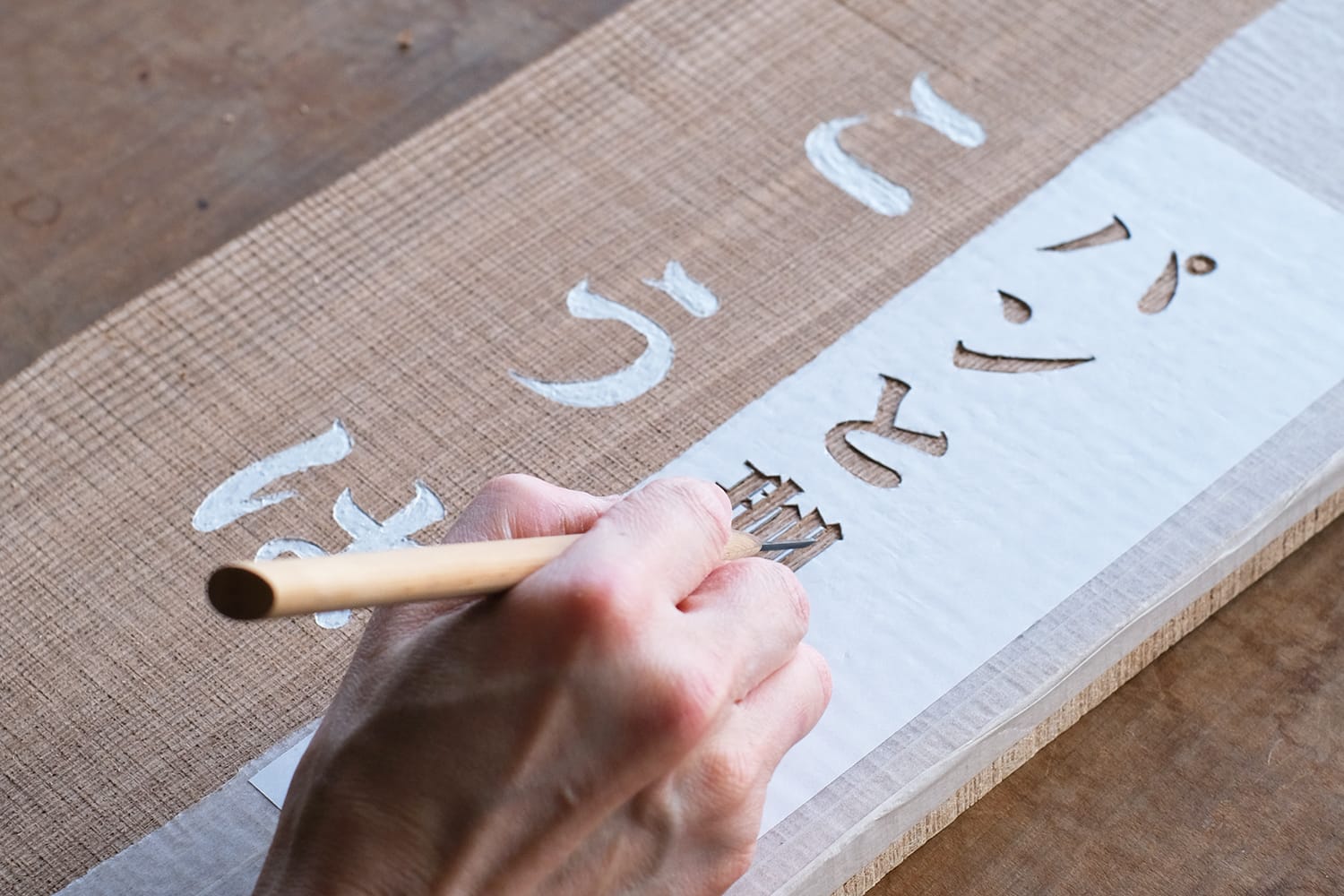 タモの板に彫刻刀で店の看板文字を彫る