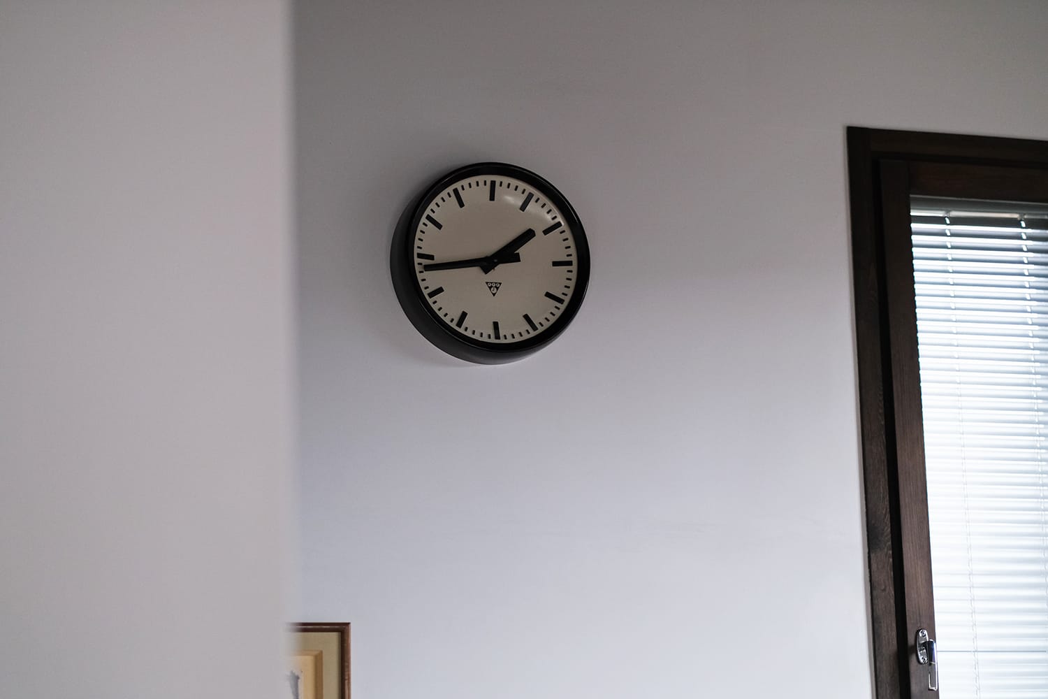 白い漆喰の壁に掛けられたPRAGOTRON（パラゴトロン）の壁掛け時計