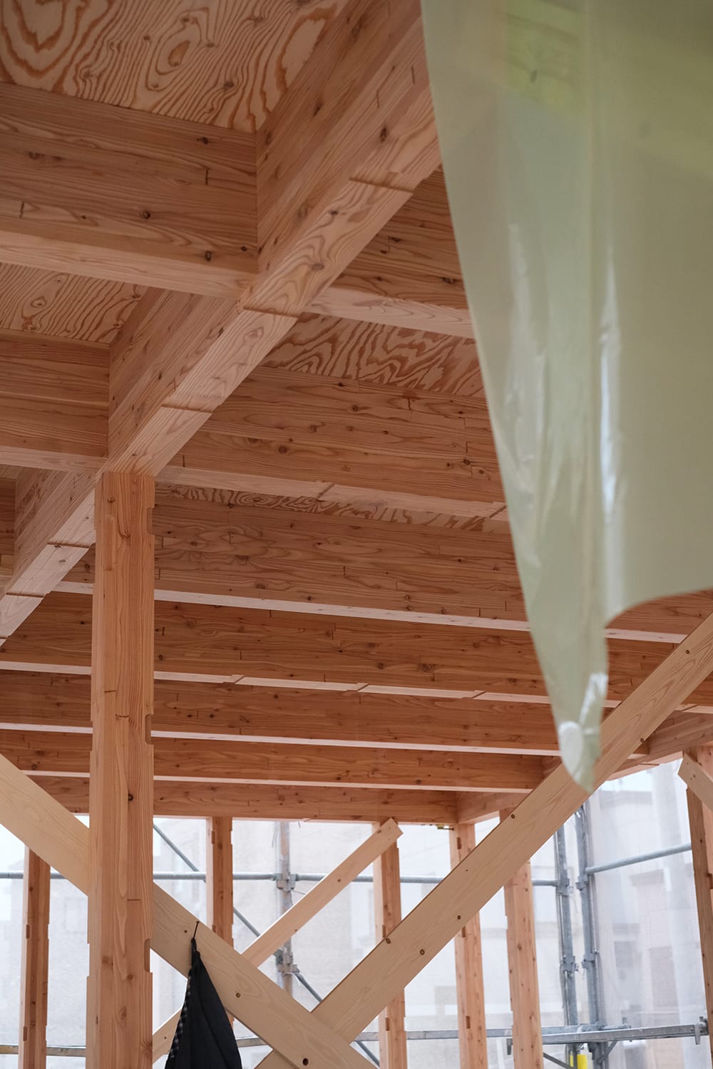 1階の天井面として見えるカラマツ集成材の床梁とカラマツ合板張り