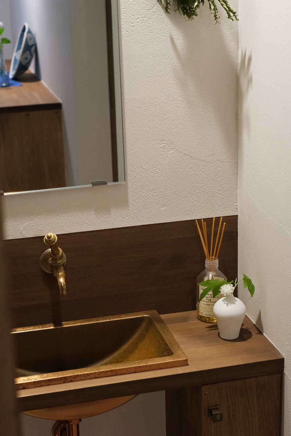 真鍮の壁付ハンドル水栓と銅製の角型ボウルの手洗いカウンター