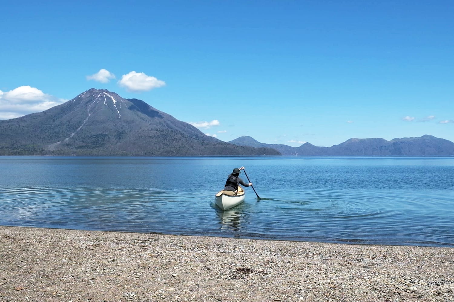 5月中旬の支笏湖畔の美笛キャンプ場から支笏湖ブルーの中にカナディアンカヌーを漕ぎ出す