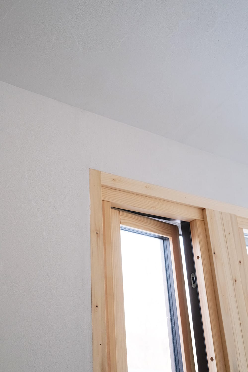 白木の木製窓とシームレスな白い壁と天井