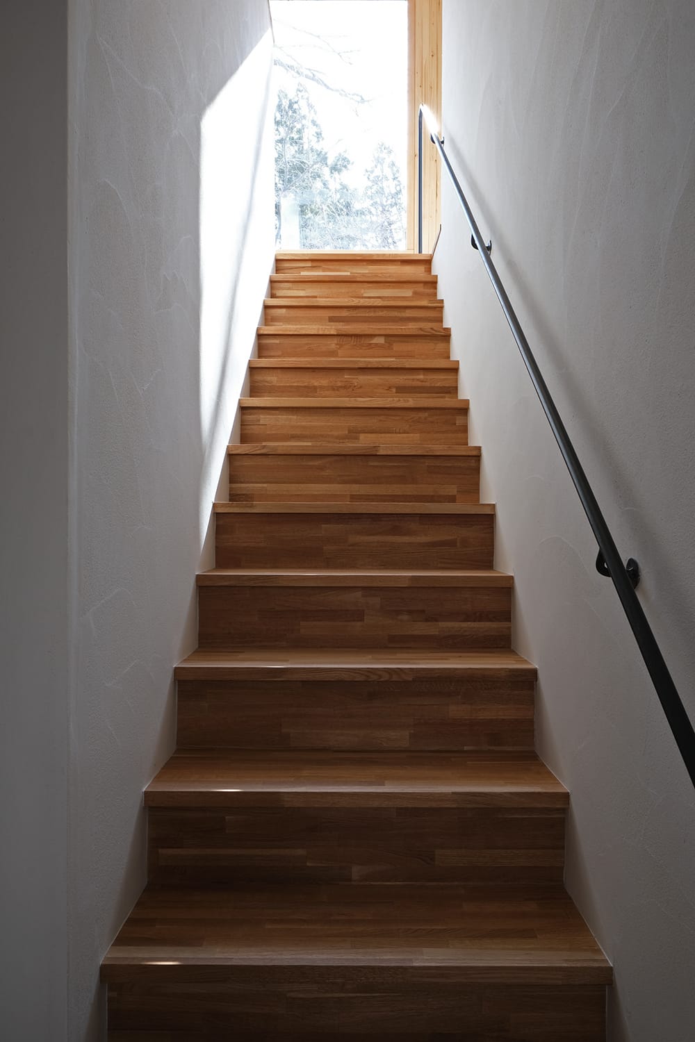 木製のストレート階段と鉄の手すり