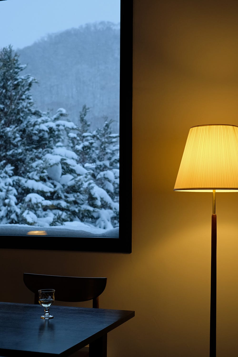 北欧ヴィンテージのフロアランプと窓からの冬景色