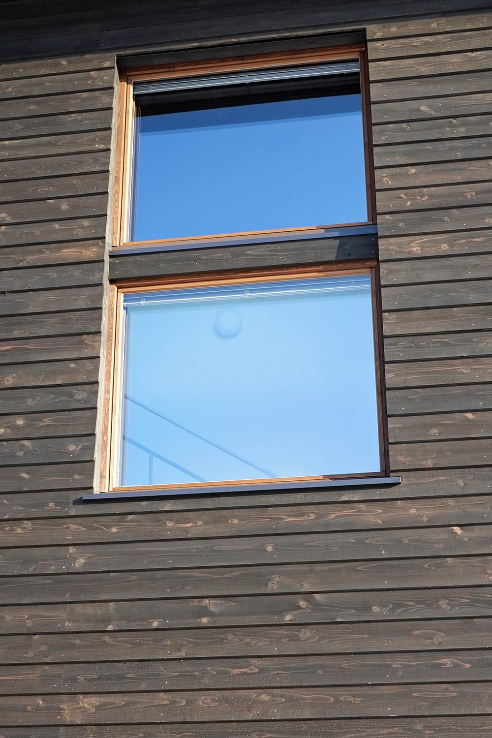 空の青色を写す木製窓
