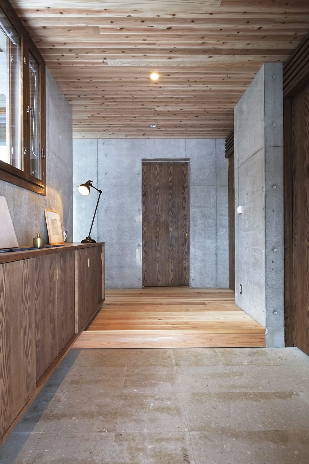 玄関土間から見る玄関ホール 札幌軟石式の土間と杉の無垢板張りの床