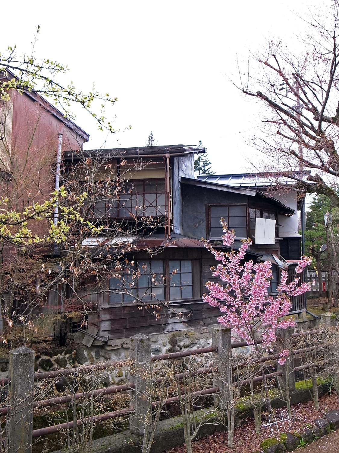 再生工事（改修工事）前の古い町家（古民家）を江名子川越しに見る外観1