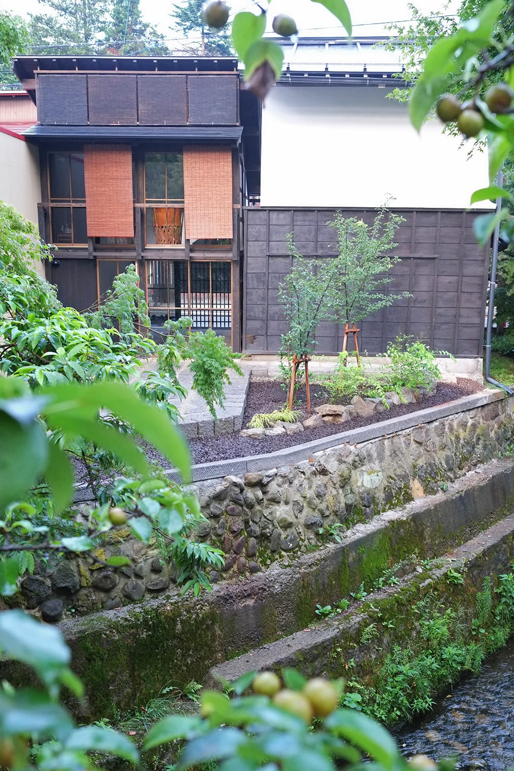 江名子川側から見た簾の掛かる再生された町家と東山白山神社の屋台蔵