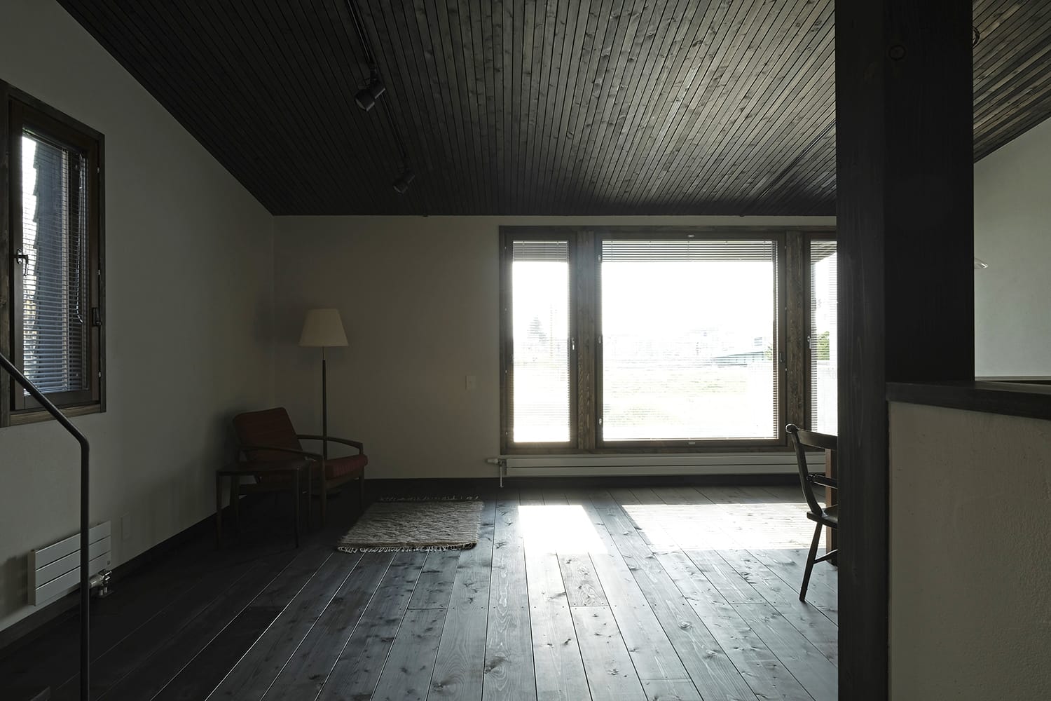小割り板張りの天井と幅広厚板張りの床のリビングルーム