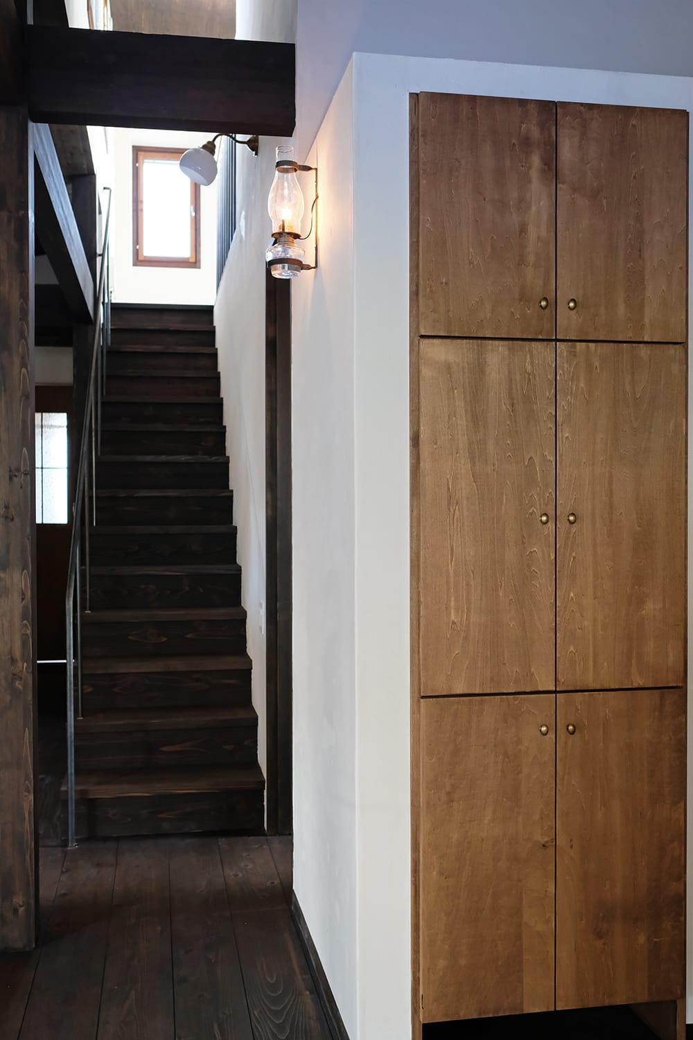 壁の収納扉とランプと階段