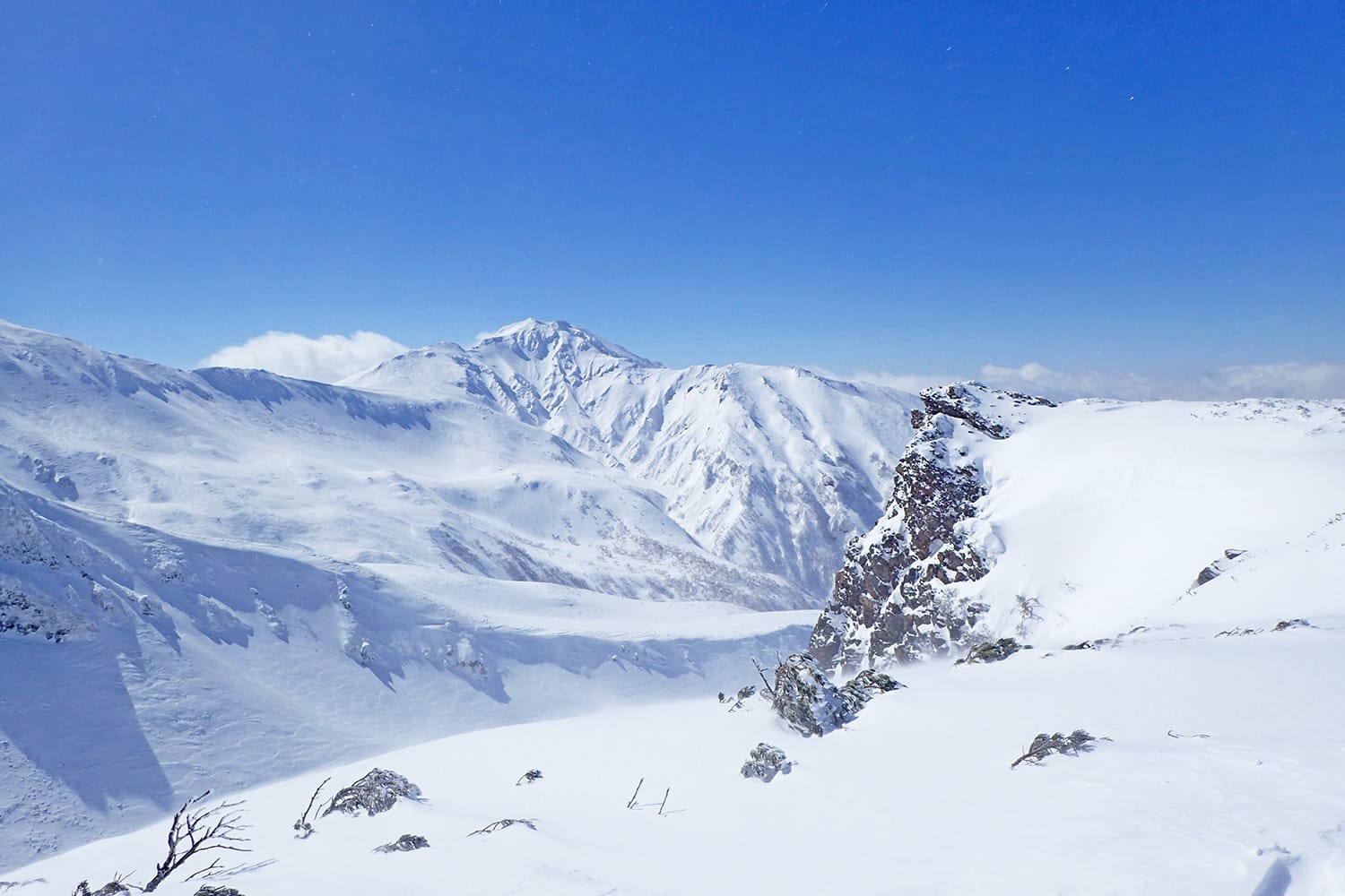 雪の三段山の尾根から眺める富良野岳