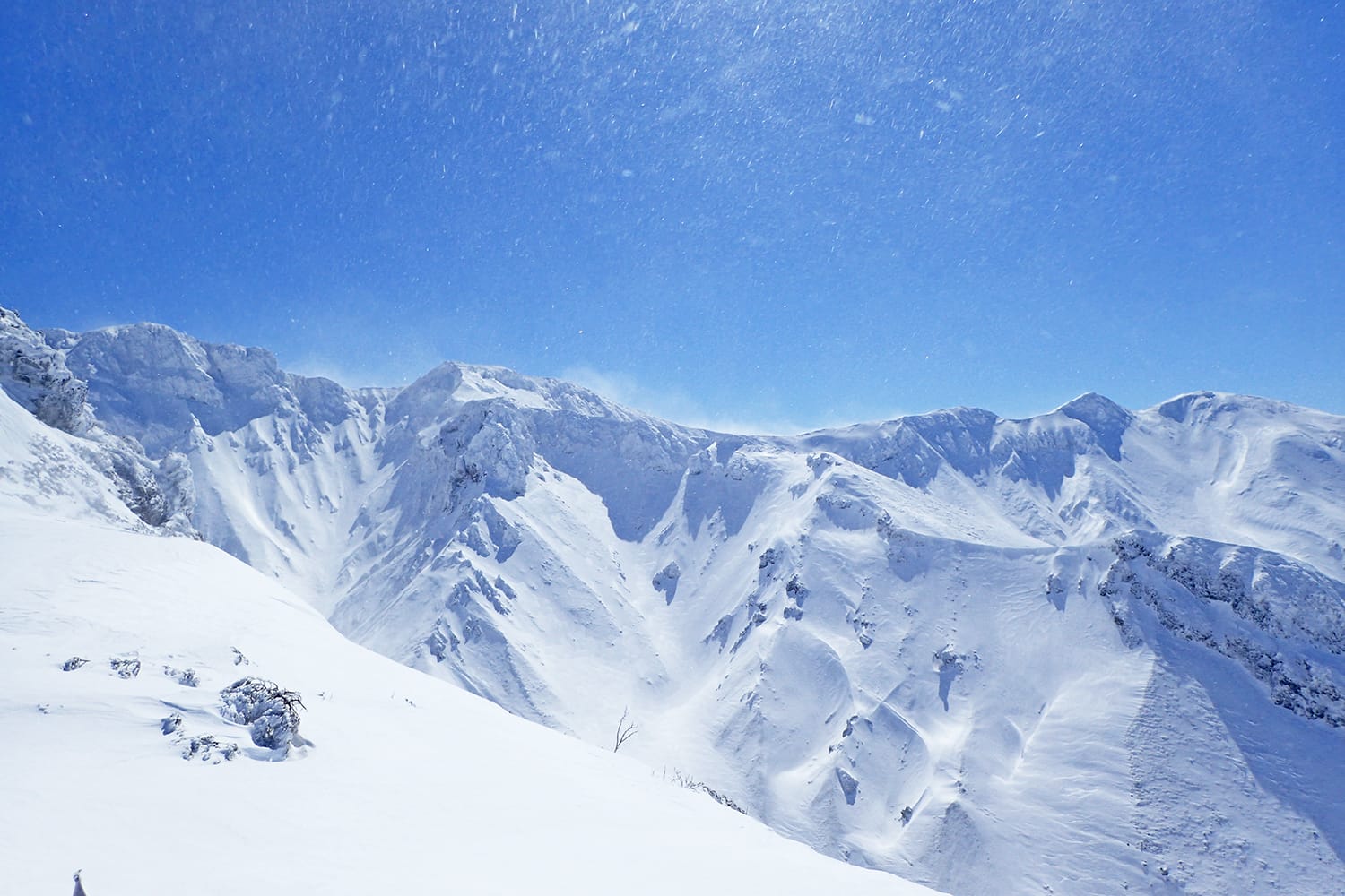 雪の三段山の尾根から眺める上ホロカメットク山・上富良野岳・三峰山