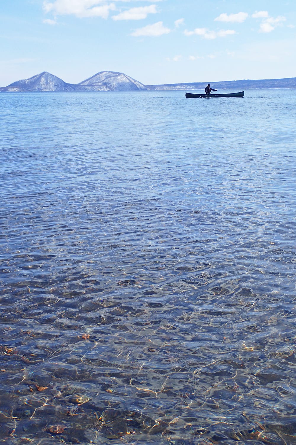 透明度が高い早春の支笏湖の水とカヌー