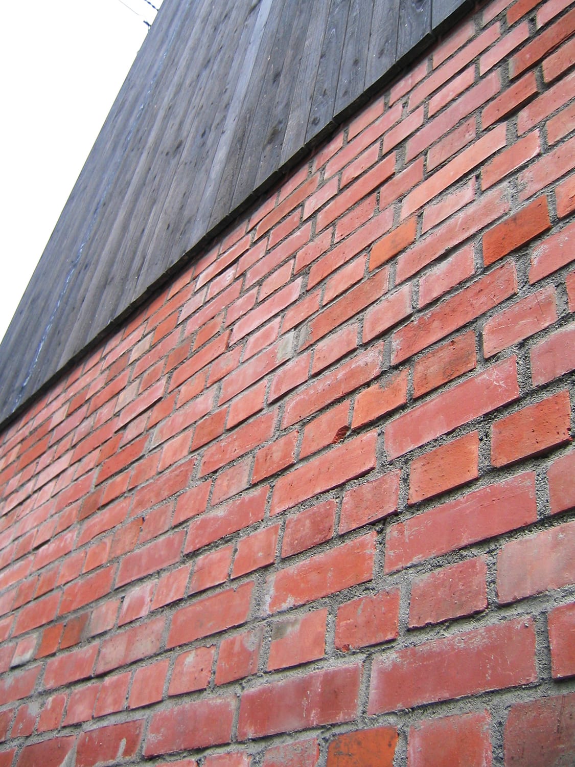 赤レンガ積みと黒い板張りの外壁