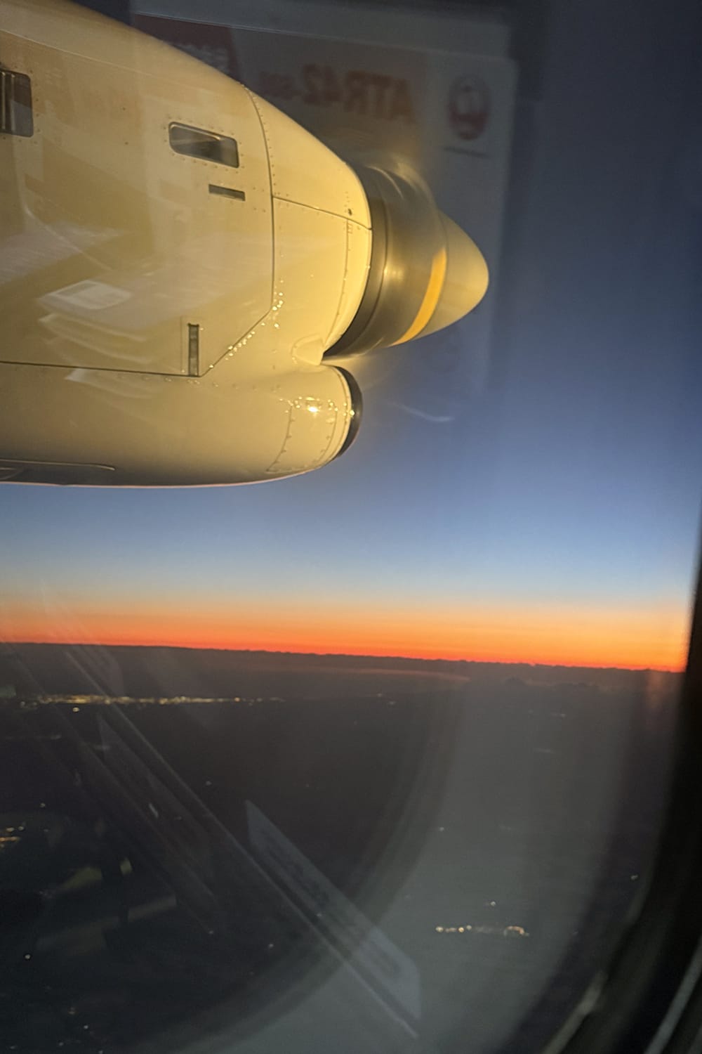 中標津発札幌丘珠行きの飛行機窓からの道東の夕焼けに染まる地平線