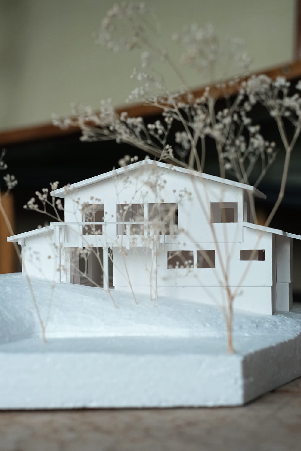 傾斜地かつ森に隣接して建つ家の模型